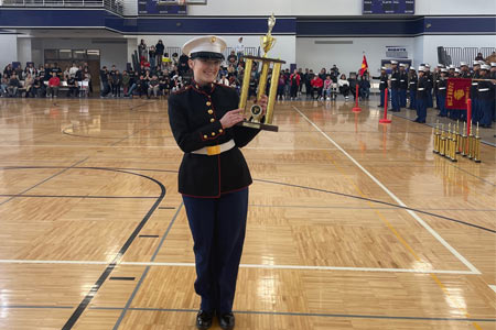 Drill Team Member Holds Trophy after Midwest Championship